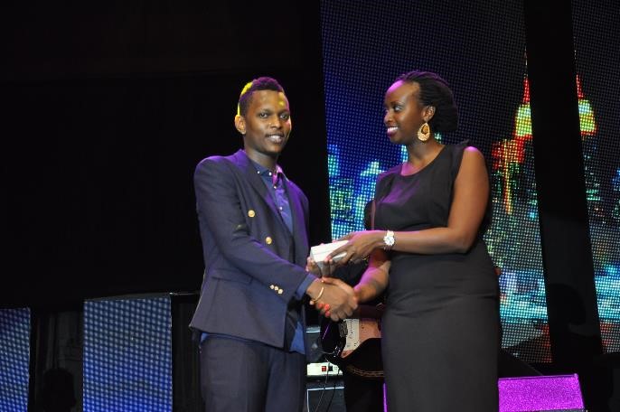Airtel Uganda's Noela Byuma hands over a brand new phone to Trace finalist Allan Tonix during the Airtel Trace Music Star finals at Serena Hotel